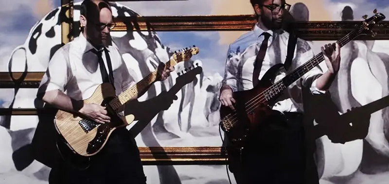Zwei Musiker spielen ihre Instrumente vor einem abstrakten Hintergrund