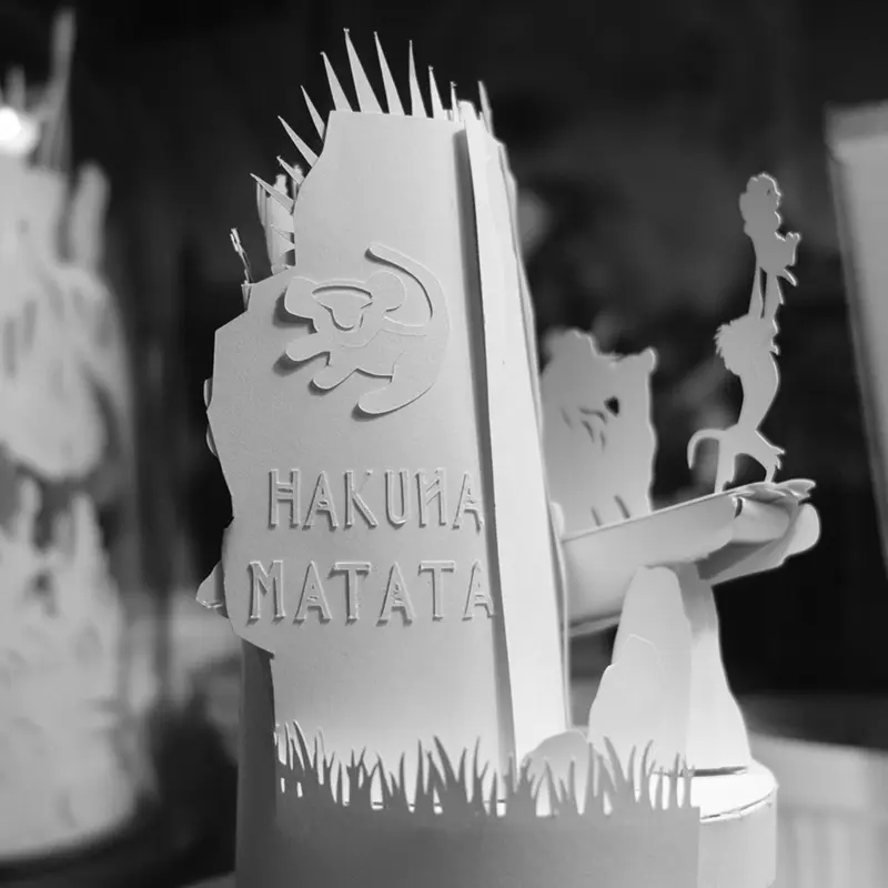 Szene aus König der Löwen aus Papier mit dem Schriftzug "Hakuna Matata"