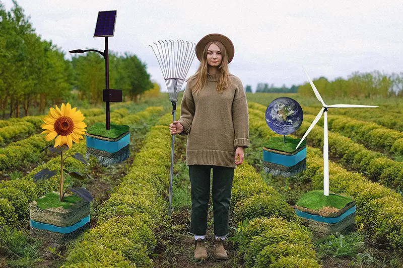 Gärtnerin steht im Feld, angebaut wurde ein Windrad, die Erde, eine Sonnenblume und eine Solaranlage